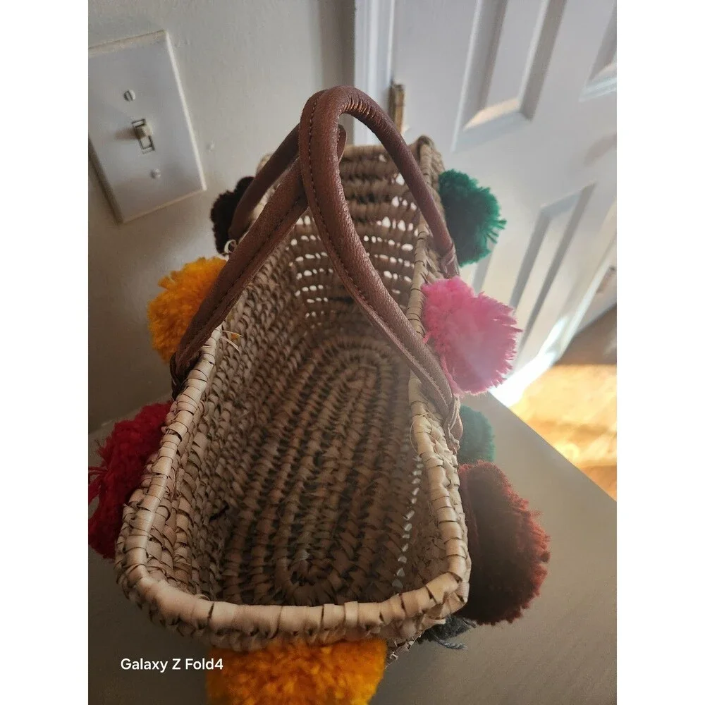 Beautiful woven straw bag with colorful pom-poms